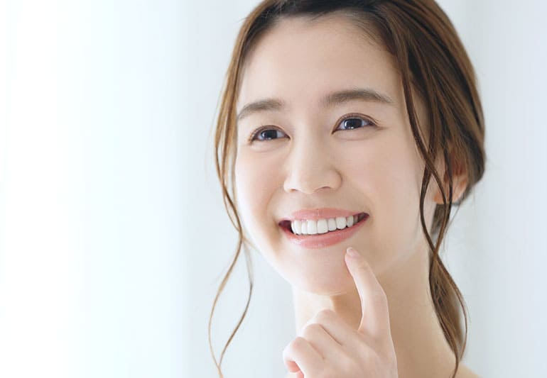鏡をみている、口元がきれいな女性